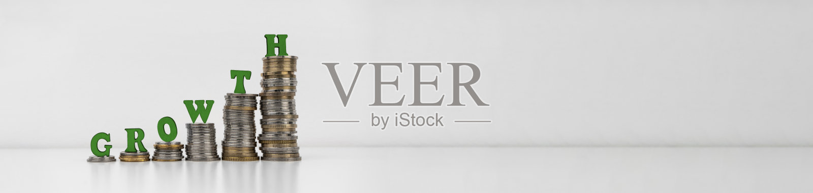 一堆硬币,上面写着字母“成长”照片摄影图片