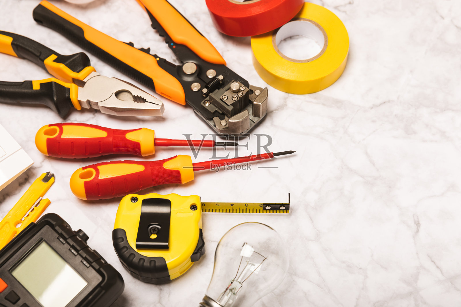 电工工具,白色大理石背景。万用表,施工胶带,电工胶带,螺丝刀,钳子,自动绝缘剥离器,插座和LED灯。弗拉特利。电工概念。工具箱。照片摄影图片