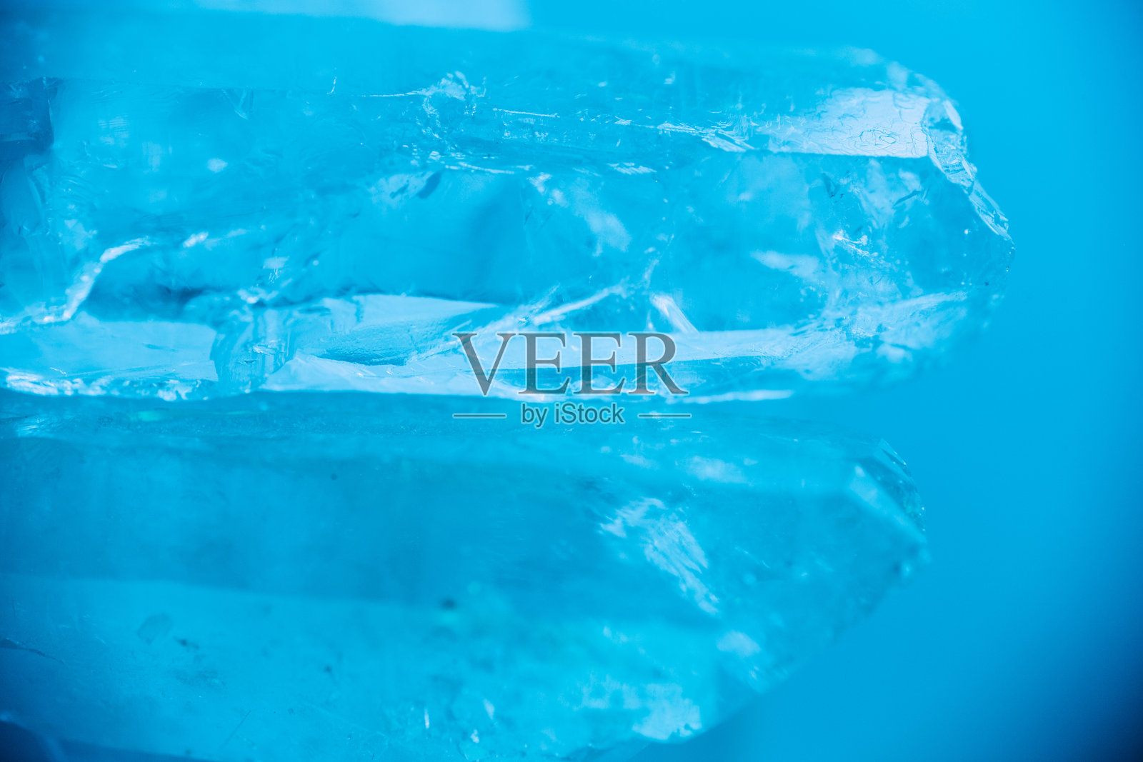 蓝色调的透明晶体。宝石的纹理。岩石晶体宏观纹理在蓝色的光。天然透明石质岩石结晶。纹理天然石水晶照片摄影图片