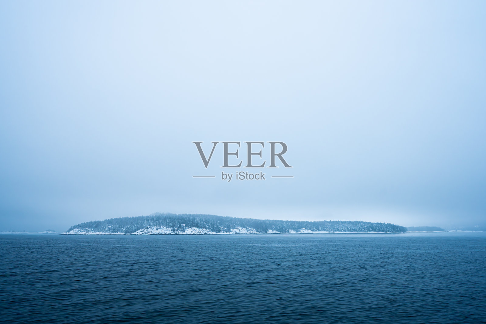 冬天阴天的雪岛。照片摄影图片