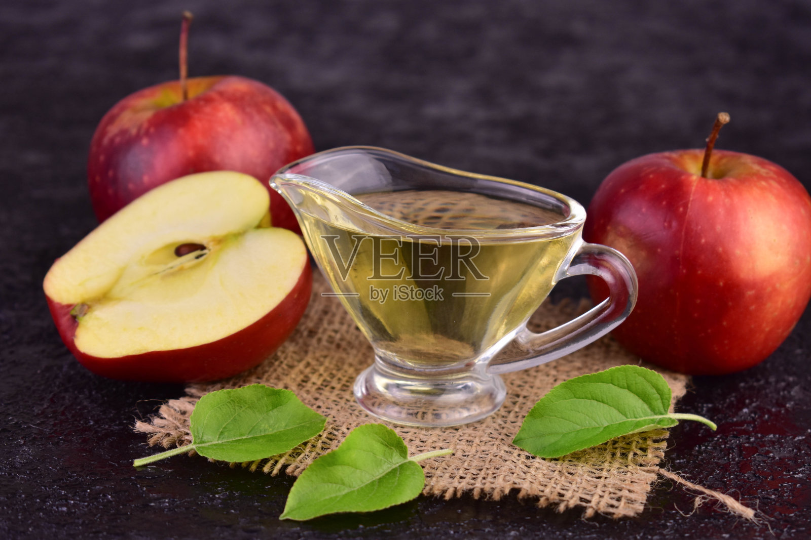 黑色背景上的苹果醋和新鲜苹果。特写。照片摄影图片