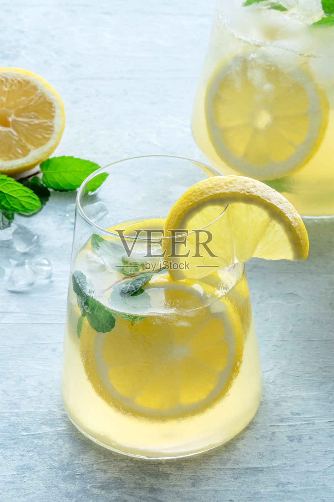 柠檬水加薄荷。柠檬水加冰喝。一个玻璃杯和一个水罐照片摄影图片