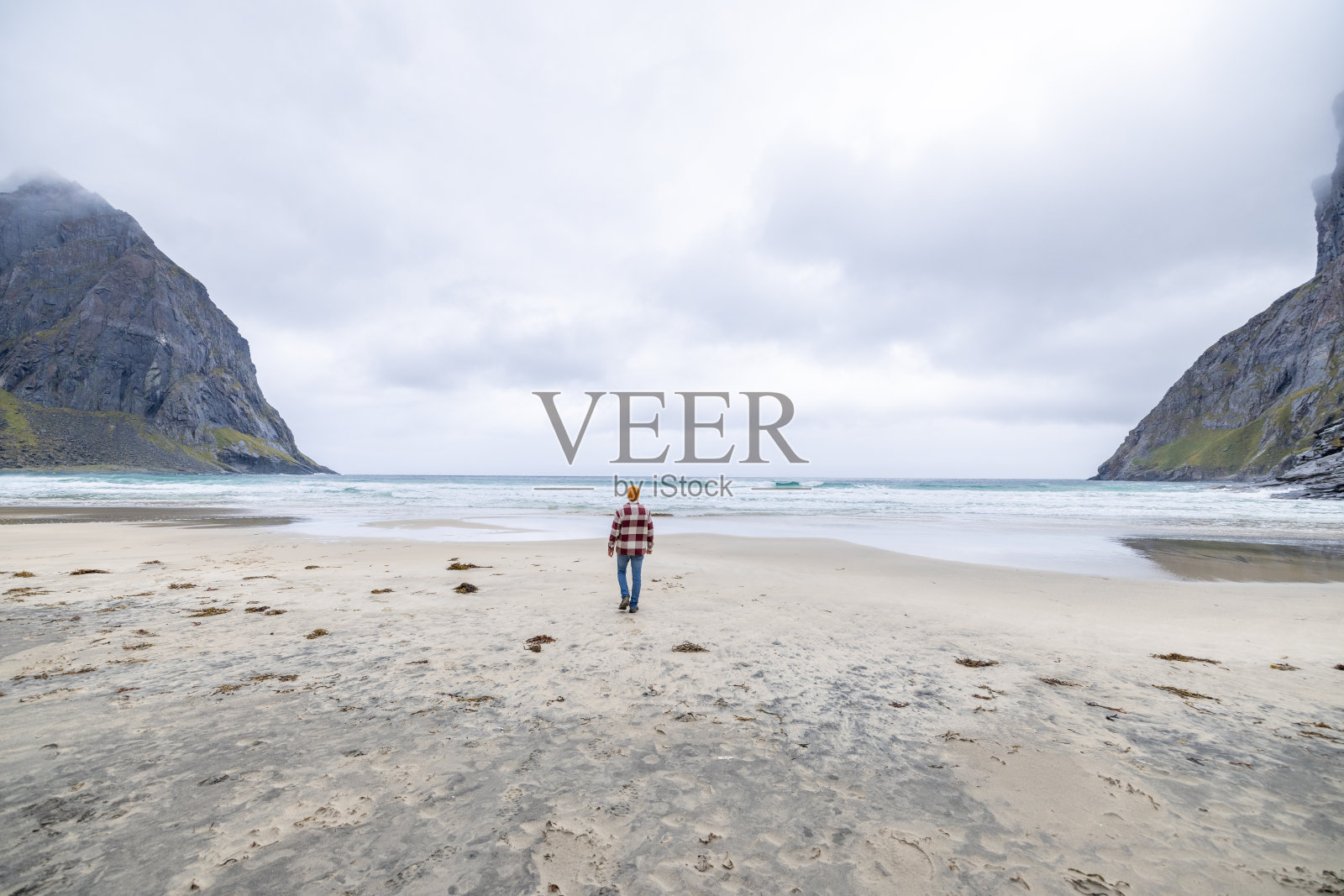 远处的挪威海滩上的人,他凝视着大海照片摄影图片