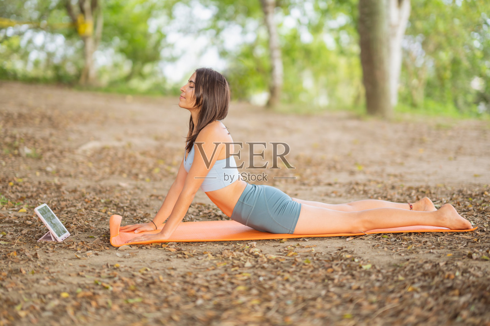 年轻女子在垫子上伸展身体。照片摄影图片