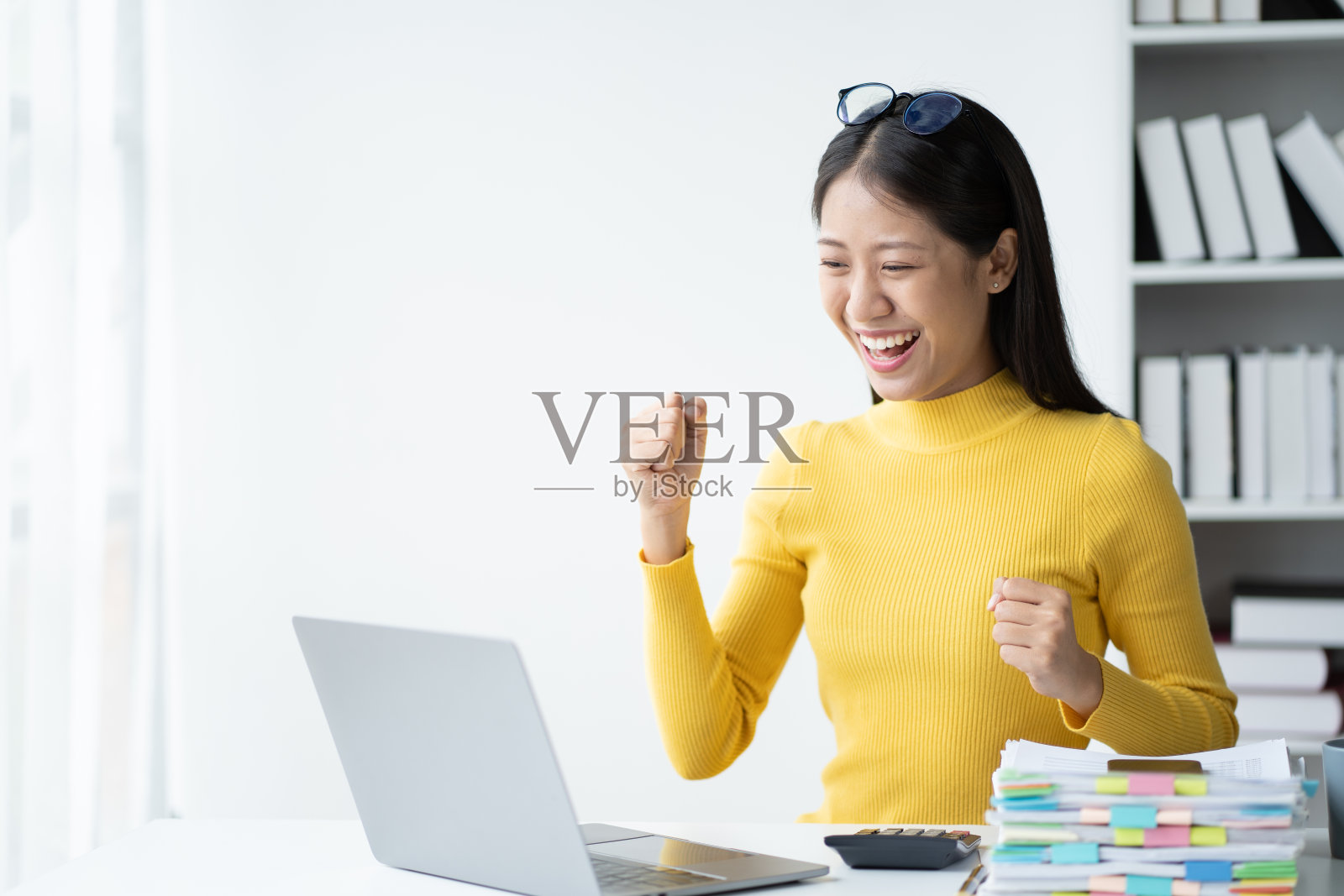 兴奋的年轻女商人在得到一个好消息后与自己庆祝。照片摄影图片