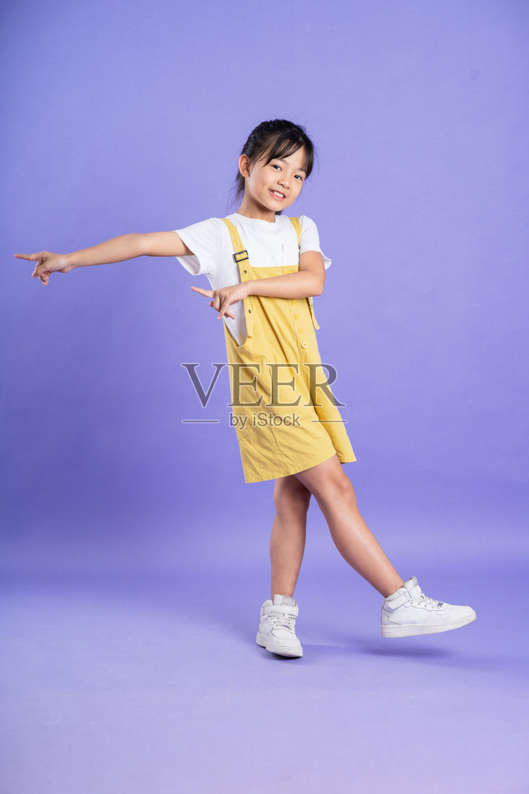 可爱的亚洲女婴在紫色背景上摆姿势照片摄影图片