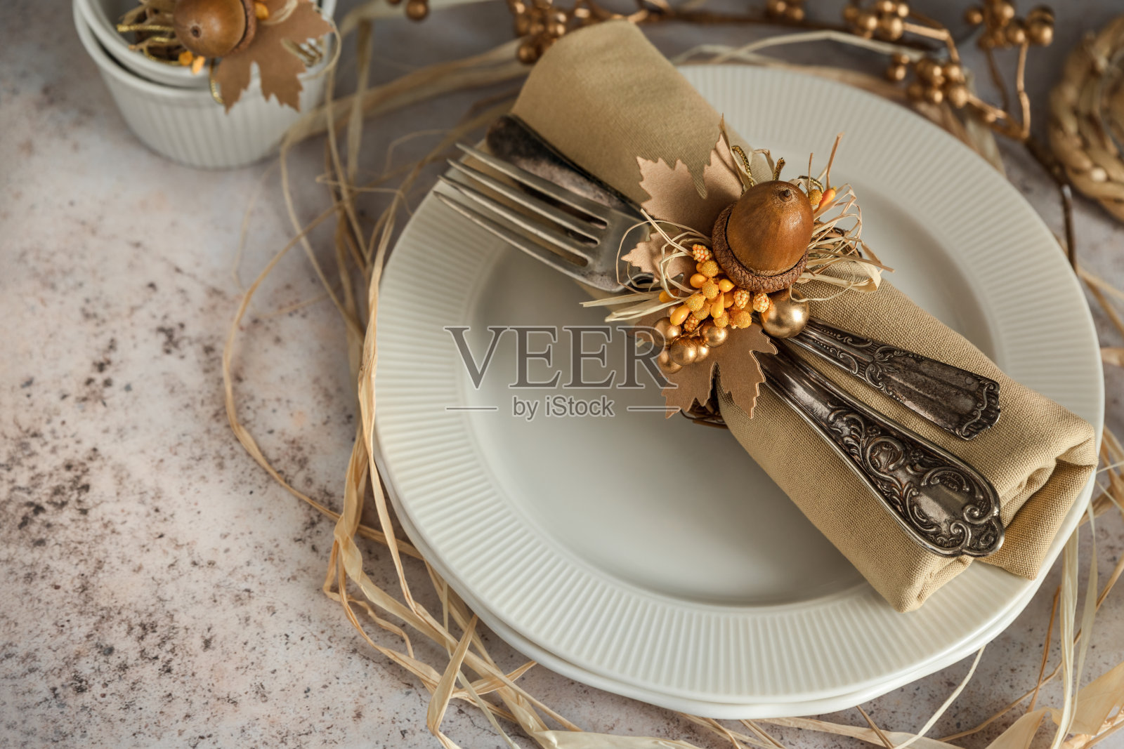 用橡子和树叶装饰的盘子上的餐巾照片摄影图片