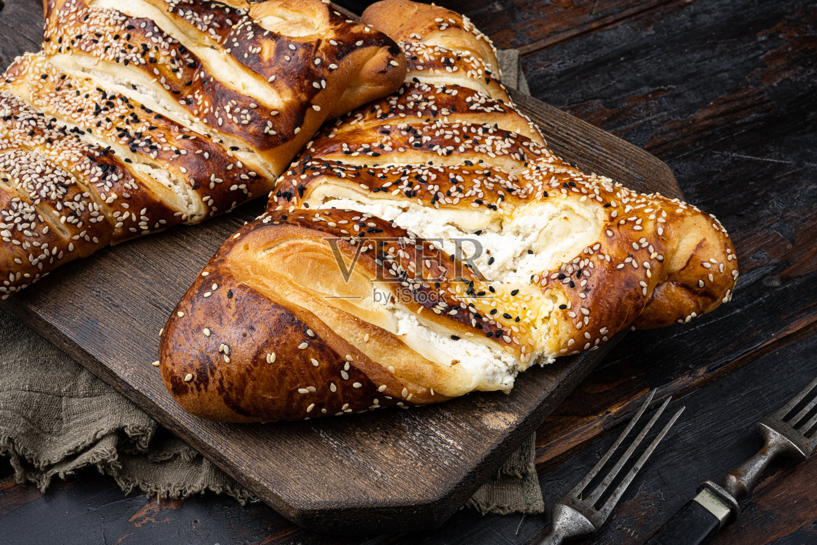 在古老的深色木桌背景上,烤制的三角形糕点配上美味的奶酪馅照片摄影图片