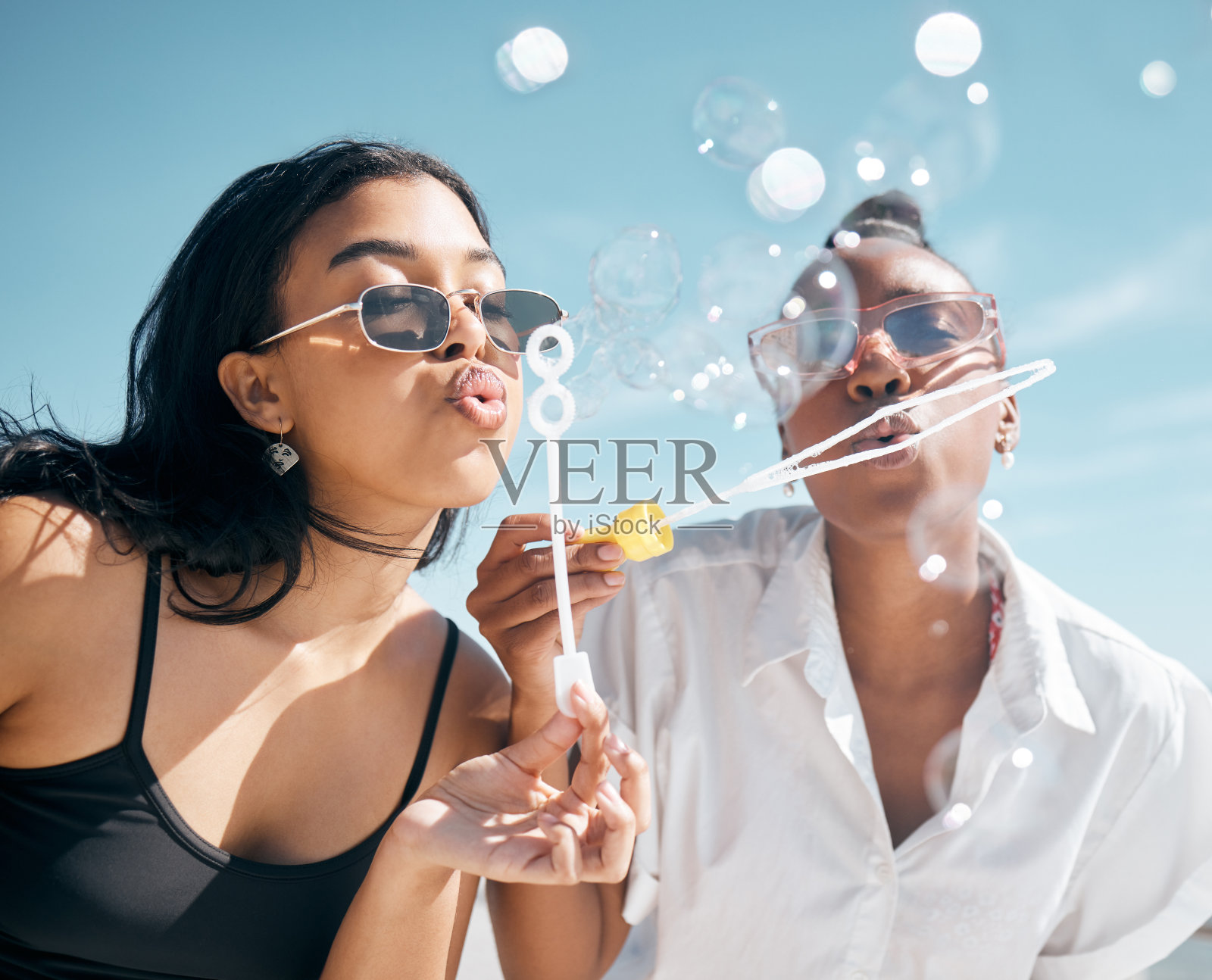 女人,朋友,和吹泡泡海滩,海洋或海洋在暑假,假日旅行或联系活动。女人在游戏中玩肥皂、泡泡棒或玩具、自由或社交休息照片摄影图片