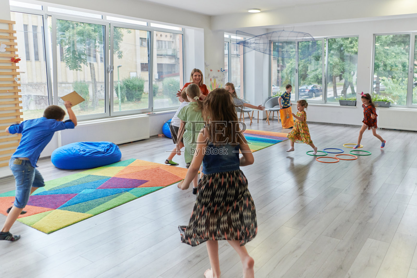 一个孩子在现代幼儿园里拥抱老师照片摄影图片