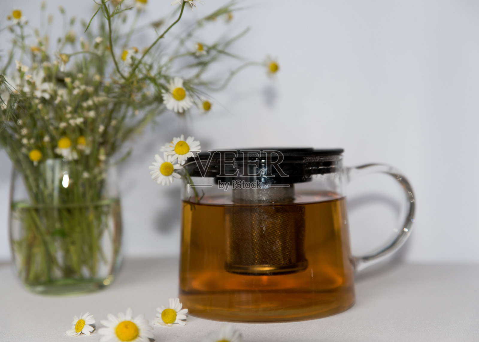 用玻璃茶壶沏茶,茶壶里有菊花照片摄影图片