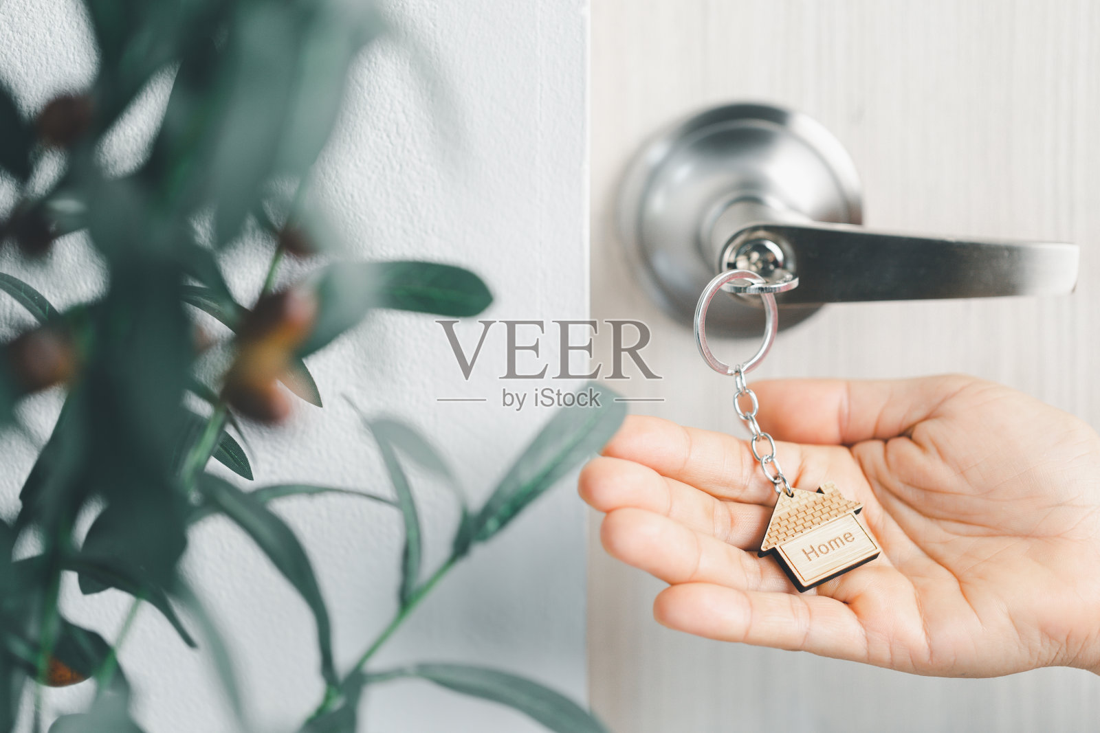 晨光中门上的钥匙特写,个人贷款概念。房屋模型和钥匙在门上。房地产经纪人提供房屋、财产保险和安全保障,经济适用房概念。照片摄影图片