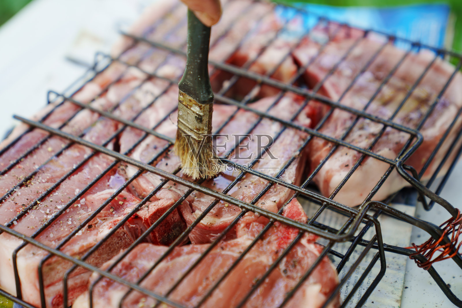 肉排在烤架上涂上植物油。在明火上烹饪照片摄影图片
