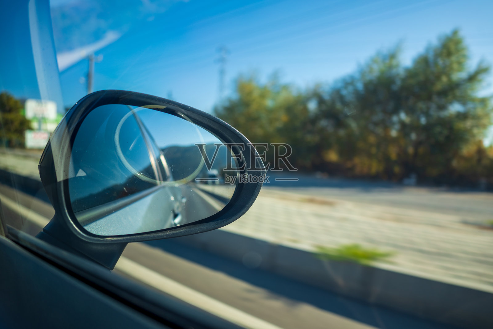 通过行驶在路上的汽车的后视镜看到的道路照片摄影图片