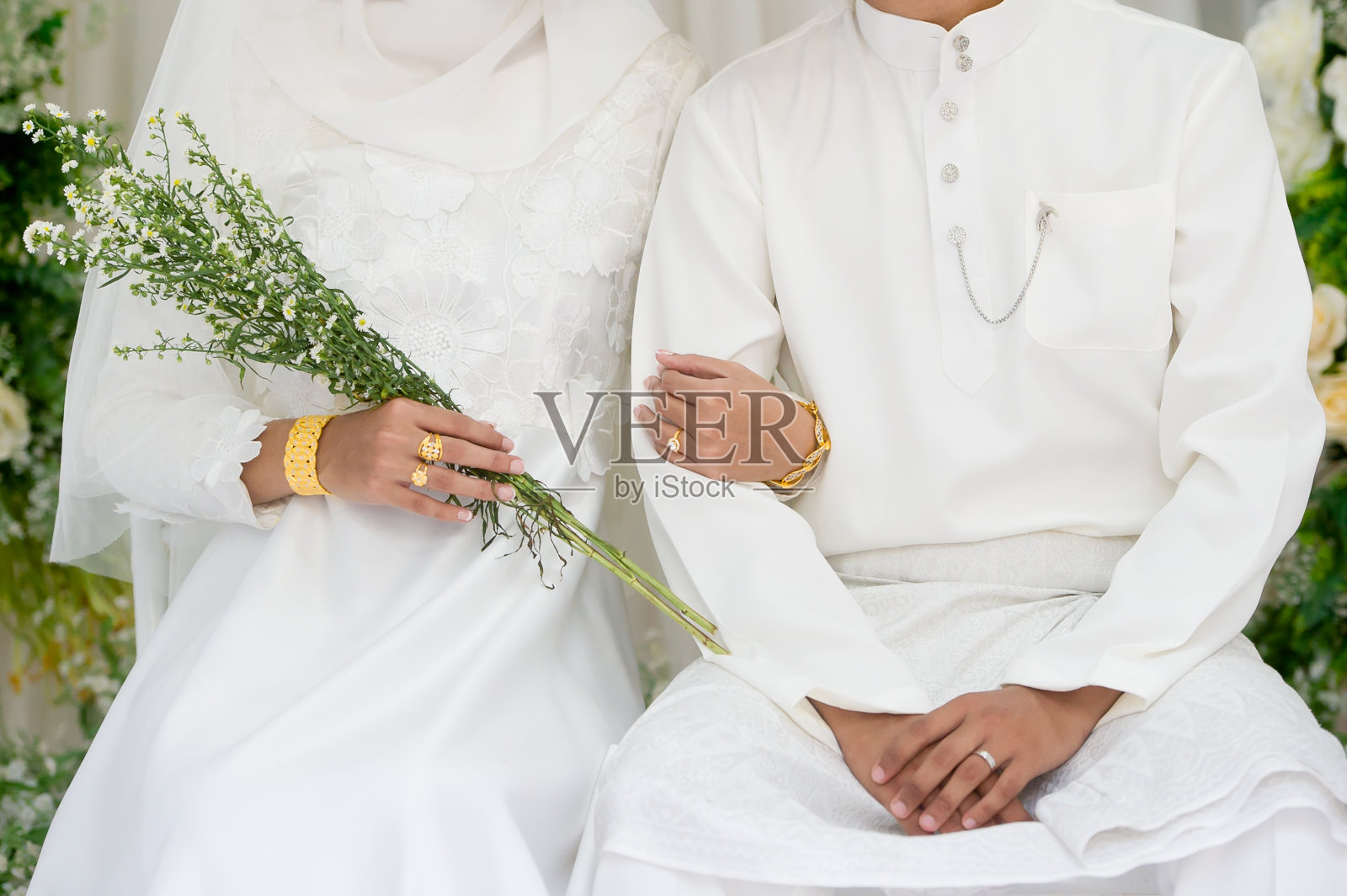 穆斯林新娘在婚礼当天身穿白色礼服,手持白色鲜花。概念的婚礼卡背景,海报,邀请卡照片摄影图片