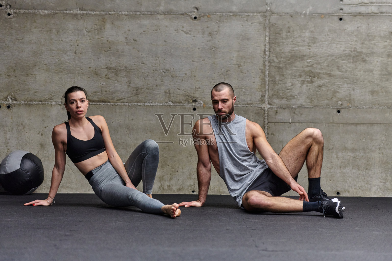 一对有魅力的夫妇在健身房一起做各种伸展运动,展示他们对健身、柔韧性和整体健康的奉献精神。与同步的动作,他们展示协调,平衡和耐力,同时支持照片摄影图片