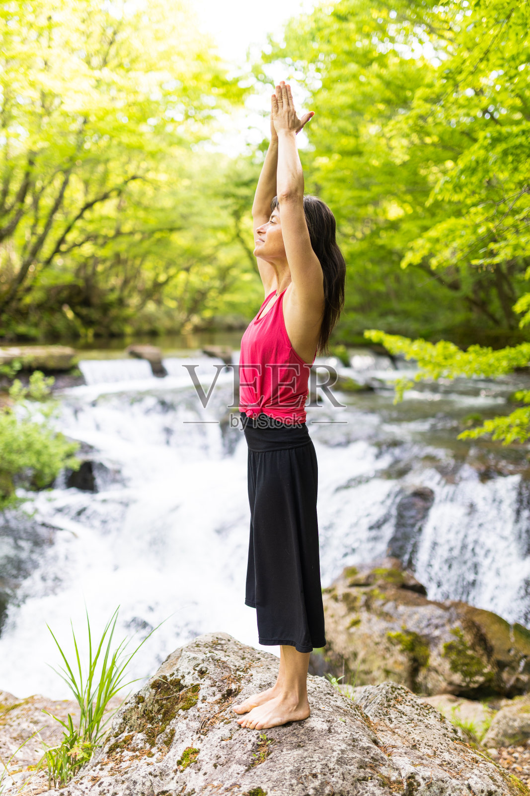 一个女人在瀑布边沉思照片摄影图片