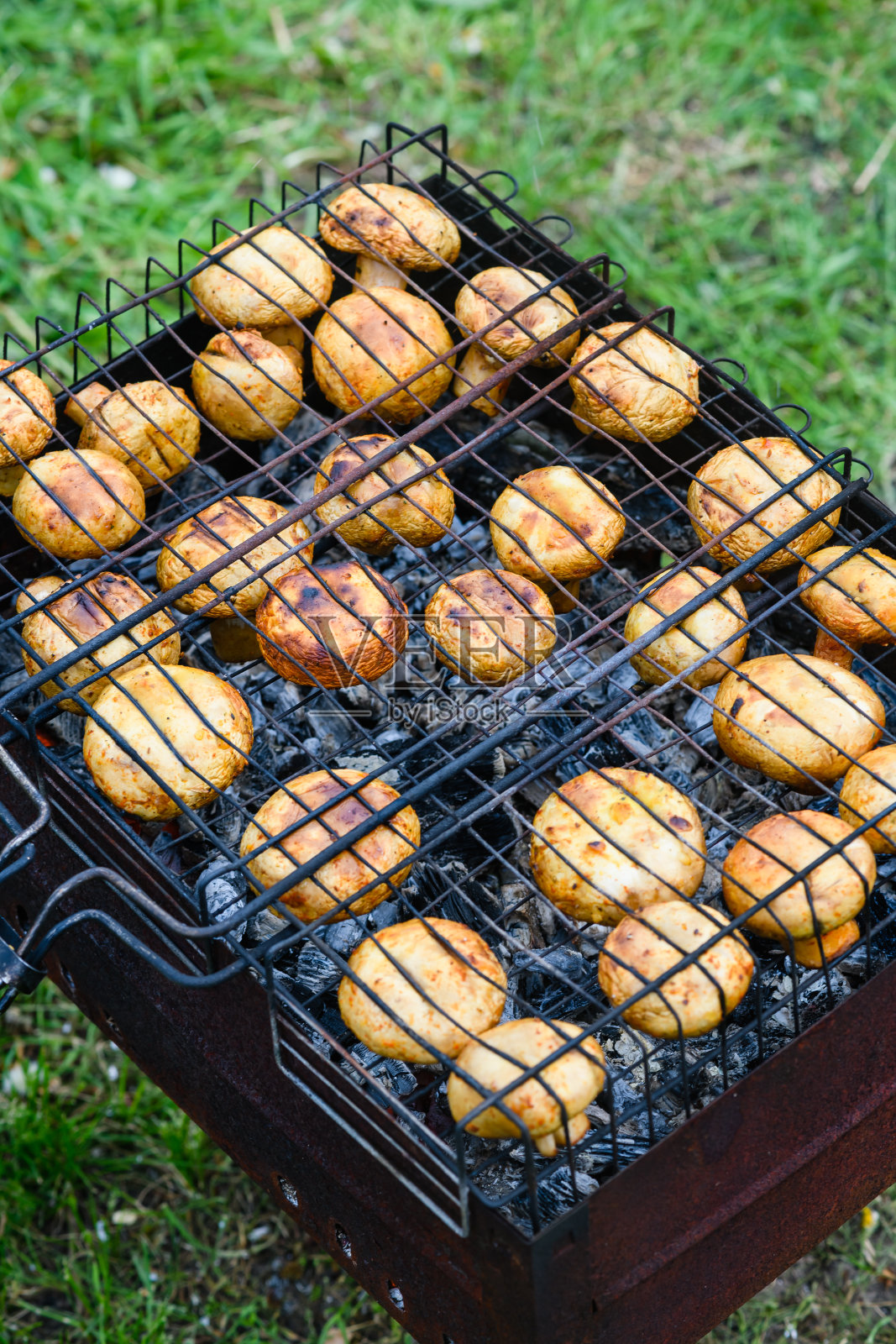 在烧烤架上烤的蘑菇,特写。照片摄影图片