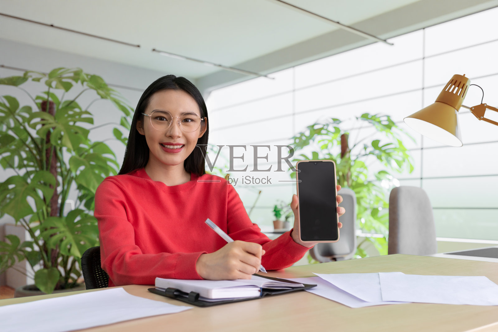 木桌上的女性拿着打开的书和咖啡杯照片摄影图片