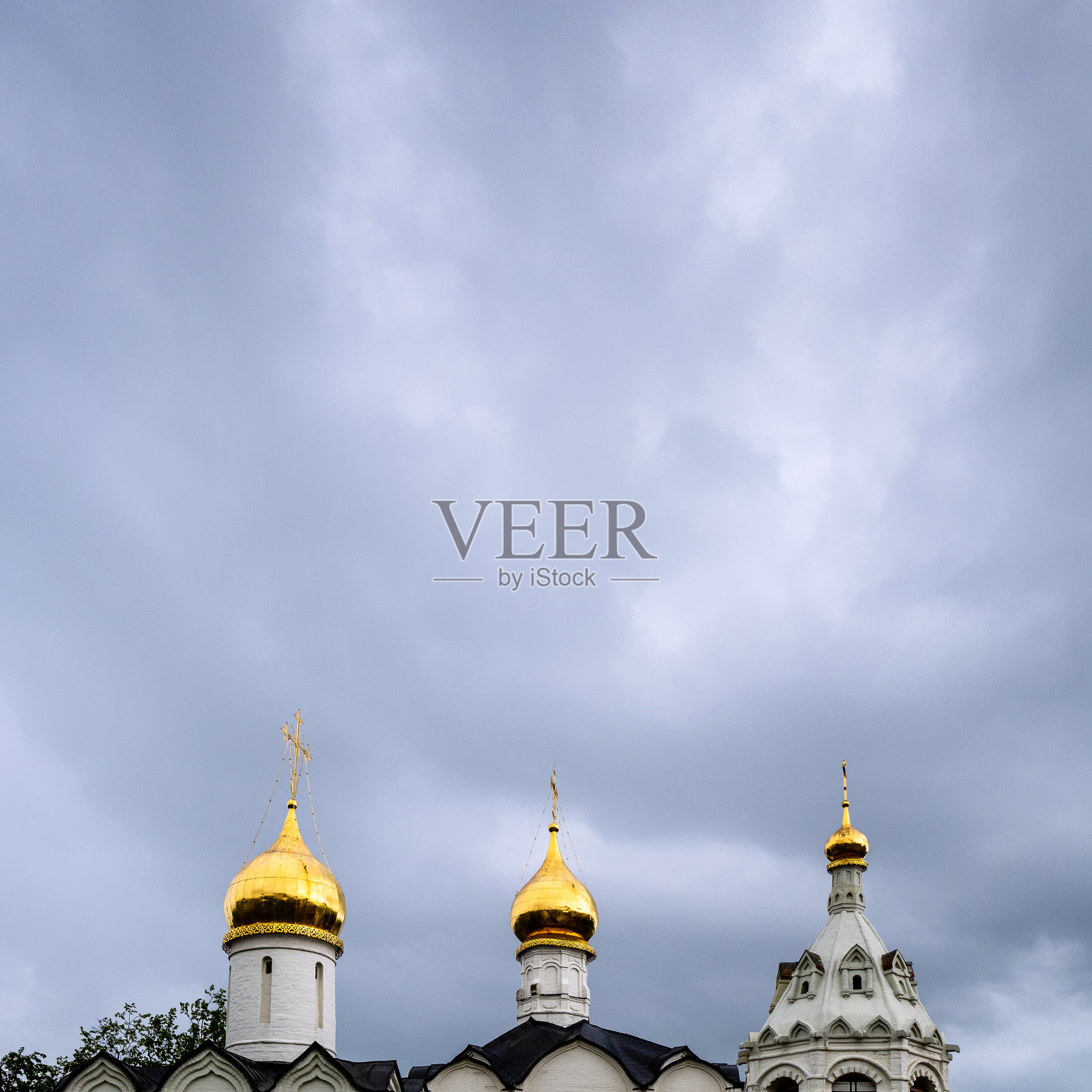 灰色多云的天空笼罩着金色圆顶的教堂照片摄影图片