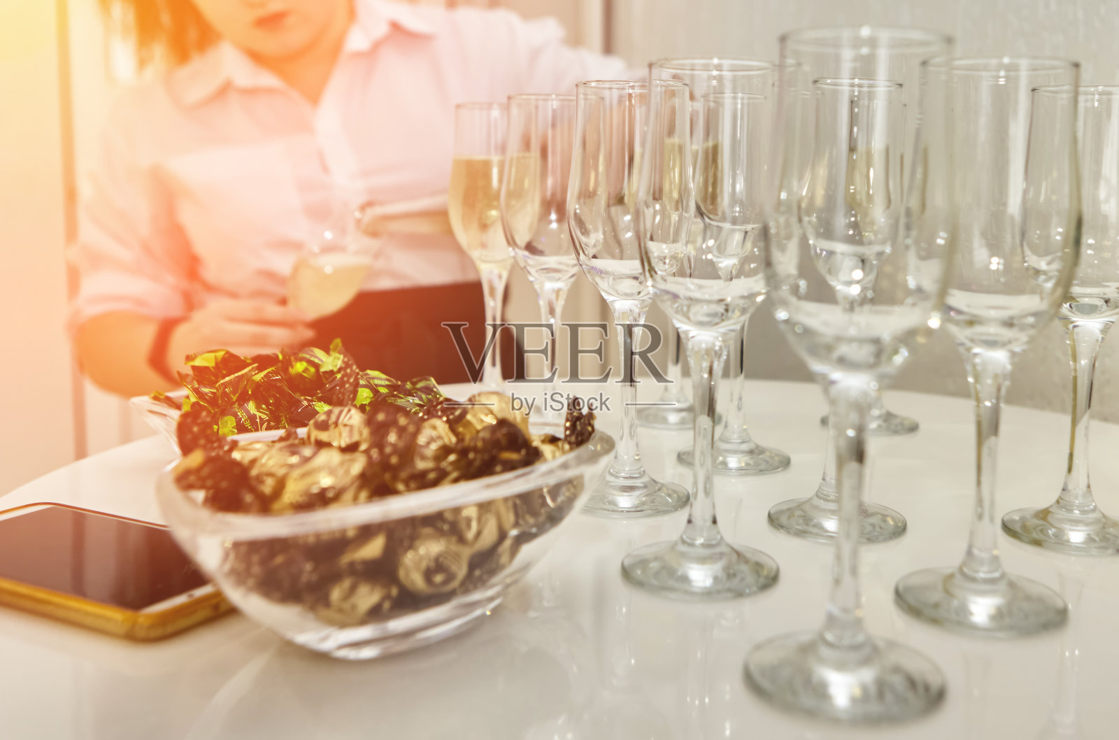 女服务员把起泡白葡萄酒分发给客人。照片摄影图片