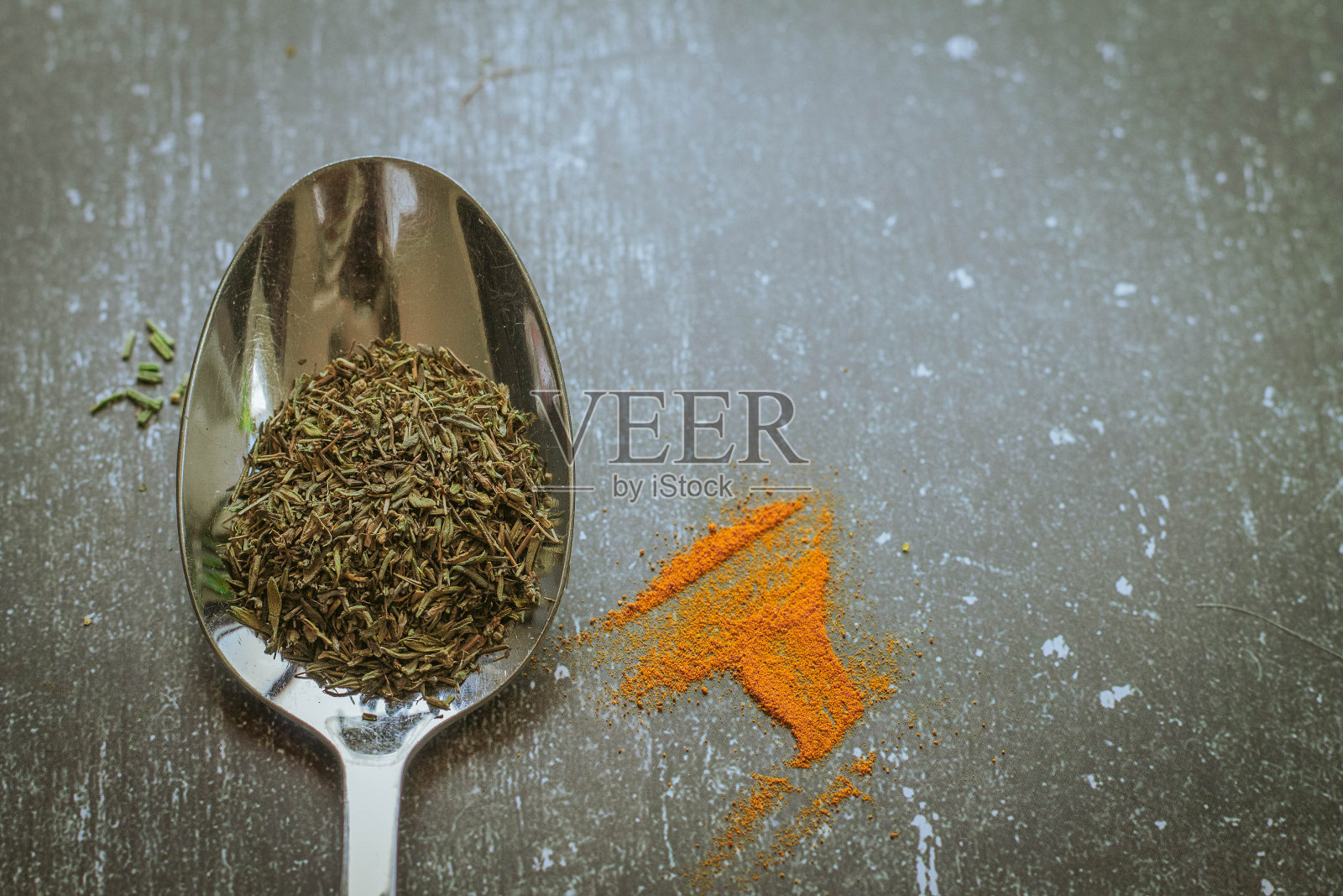 黑色背景上盛有香料和香草的勺子。食品和烹饪材料。照片摄影图片