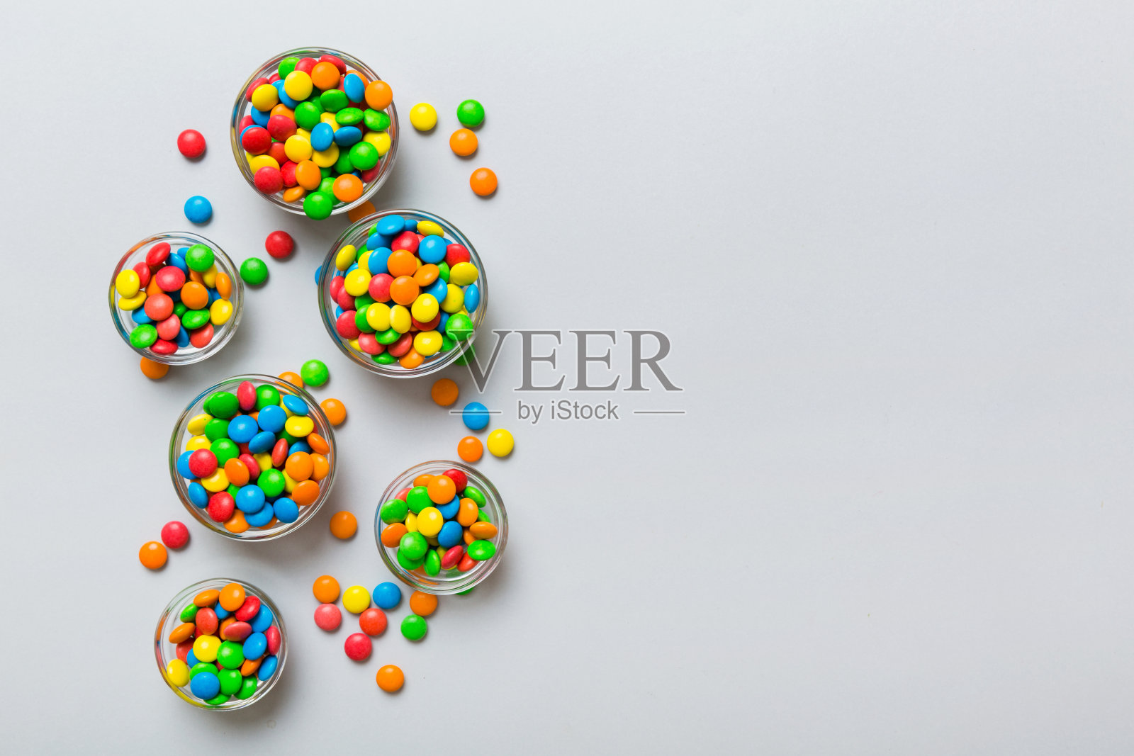 不同颜色的圆形糖果放在碗和罐子里。大品种的糖果和糖果的俯视图与复制空间照片摄影图片