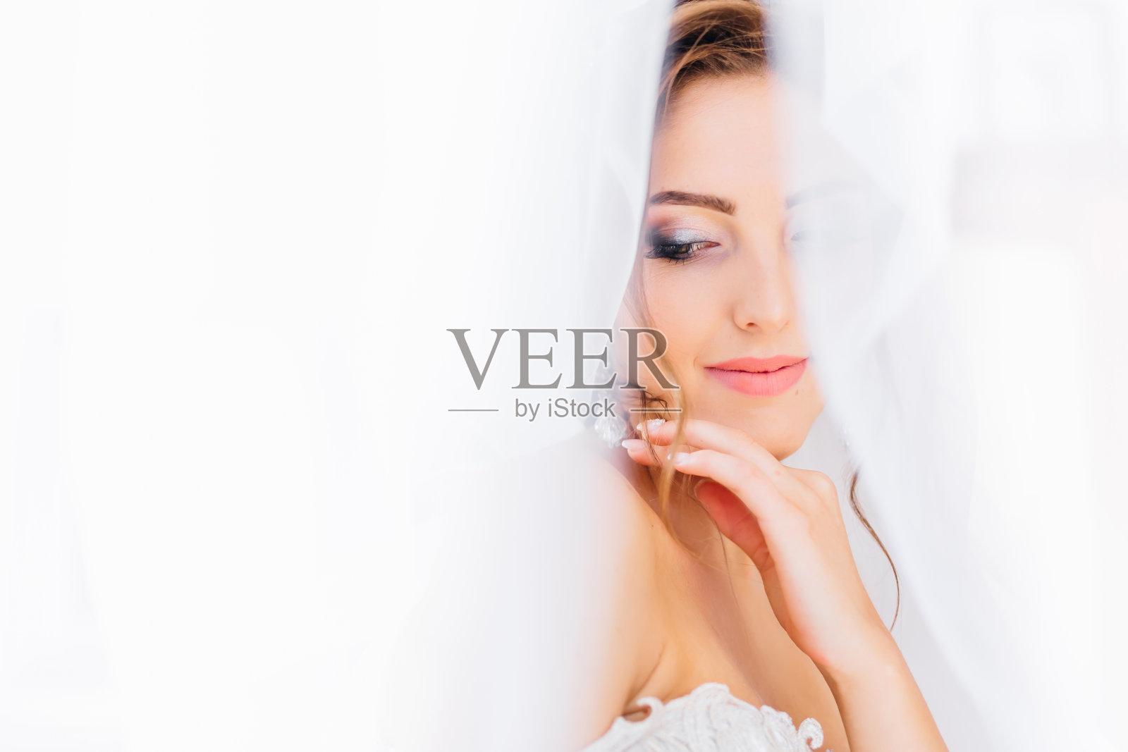 迷人的年轻模特戴着新娘的面纱摆姿势的特写肖像照片摄影图片