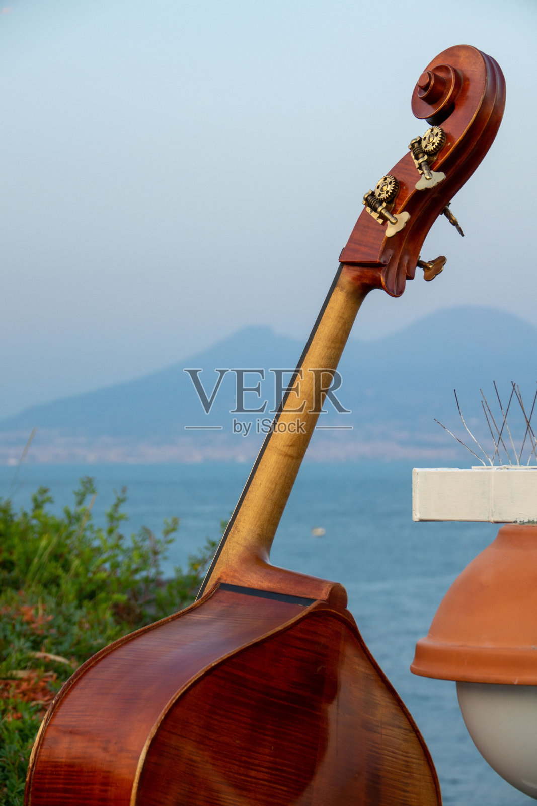 以那不勒斯湾维苏威火山为背景的低音提琴照片摄影图片