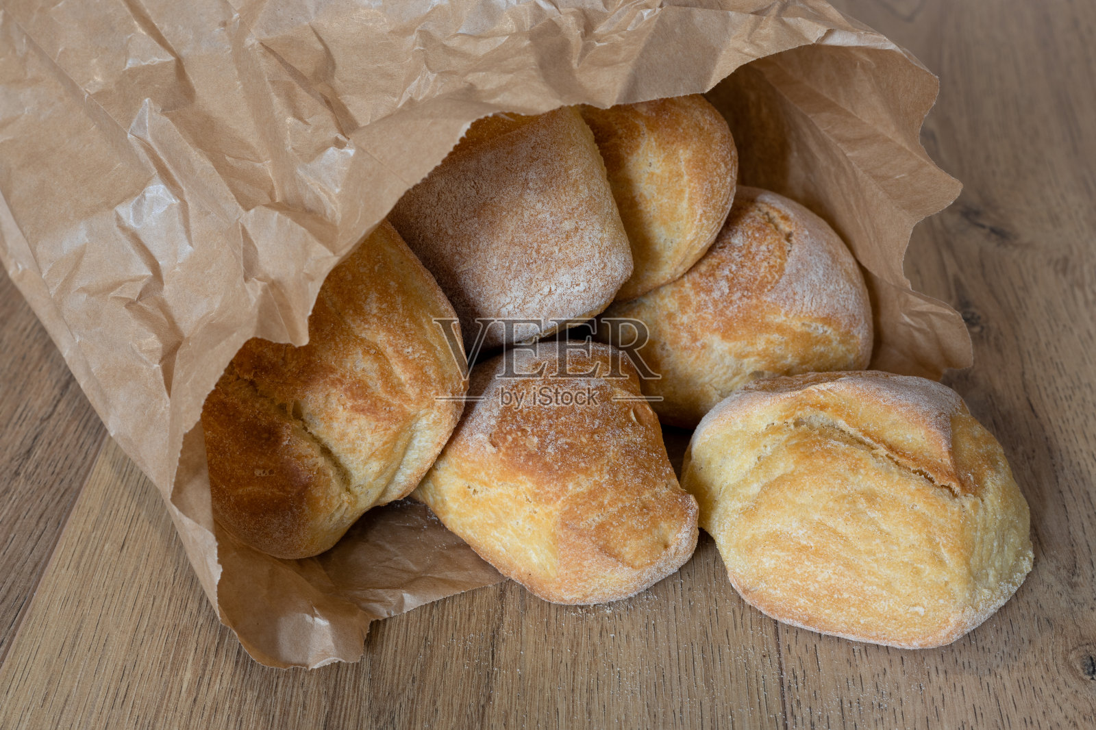 木桌上的棕色纸袋里装着意大利手工面包照片摄影图片