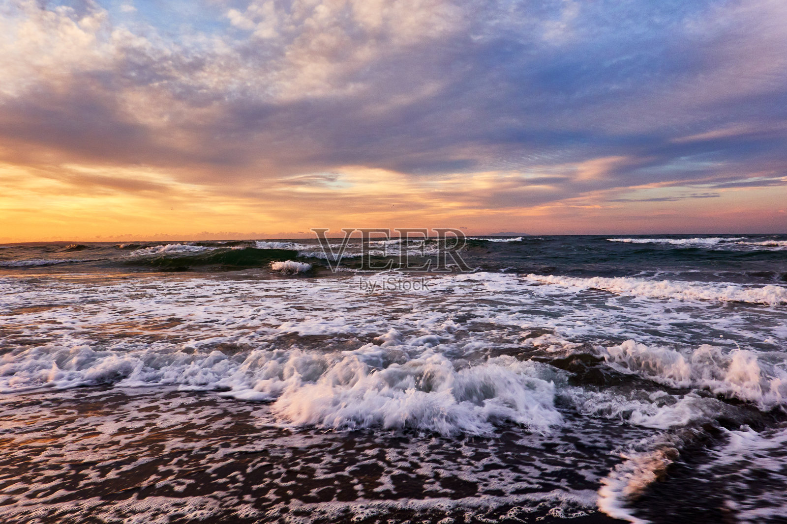 日出时,大海的风景与海浪撞击喜怒无常的天空照片摄影图片