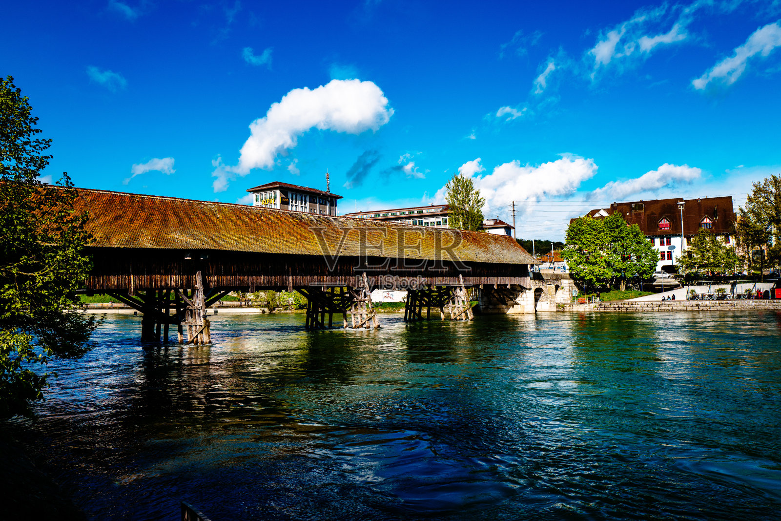 蓝天下的河面上有盖的桥照片摄影图片