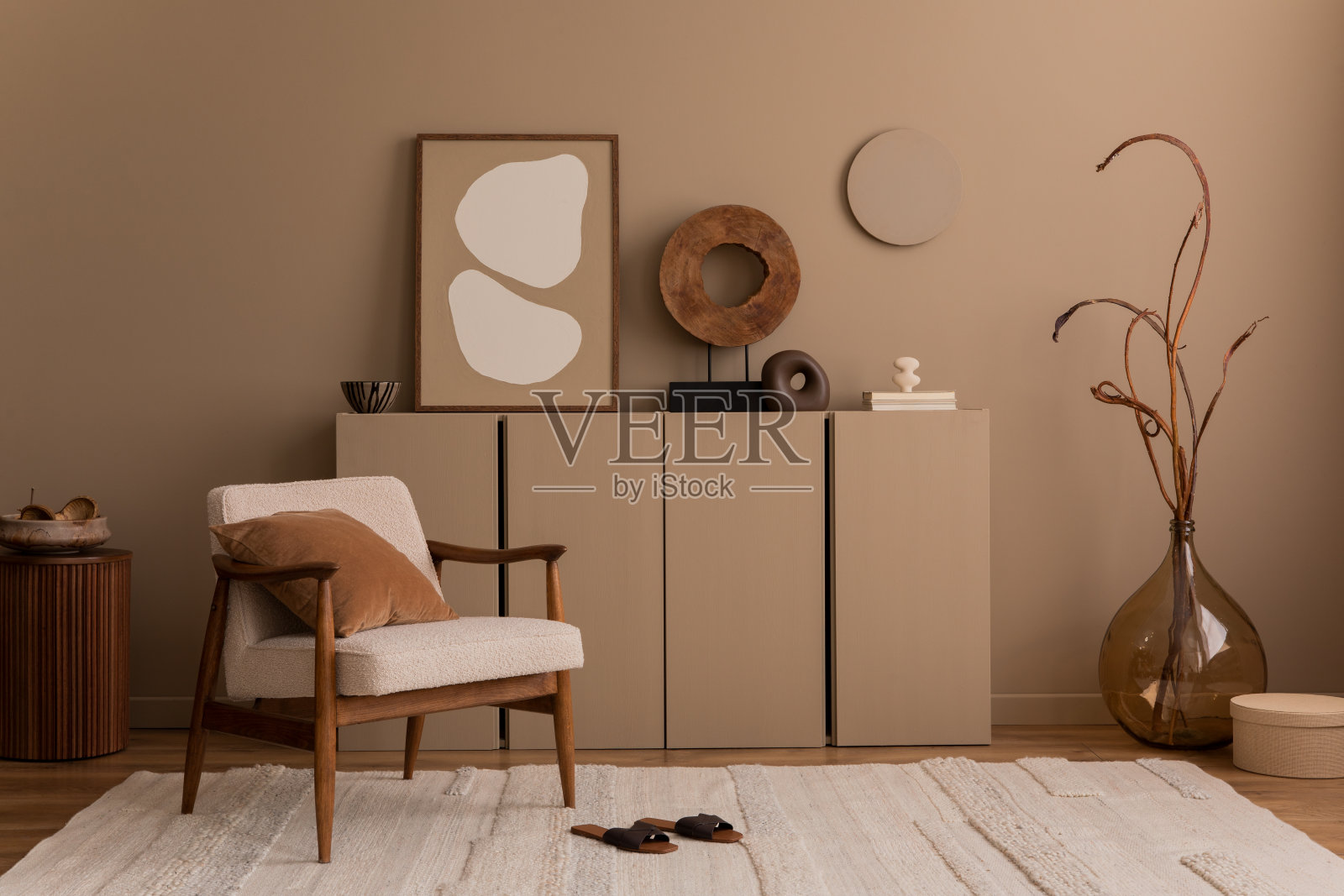 客厅内部的创意组成,模拟海报框架,圈圈扶手椅,枕头,带树枝的花瓶,木制雕塑,拖鞋,米色地毯和个人配件。家居装饰。模板。照片摄影图片