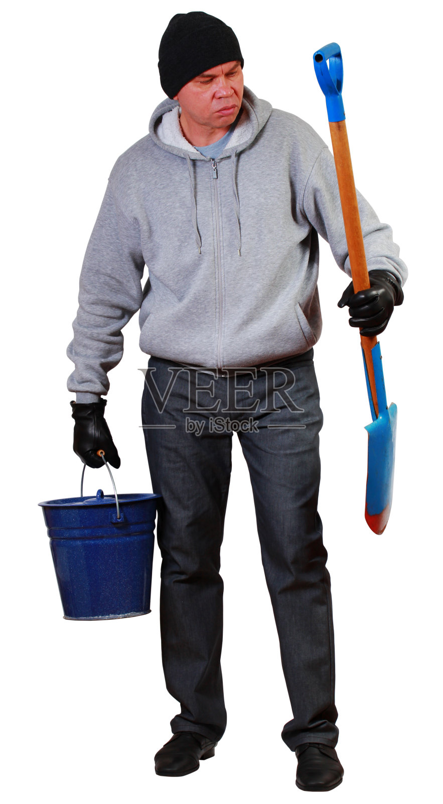 一位身穿连帽衫、头戴针织帽的农民手持铲子和水桶照片摄影图片