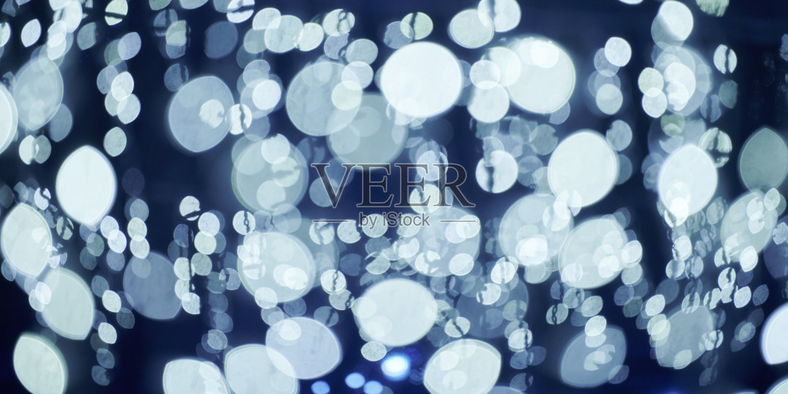 圣诞花环的蓝灯散景,模糊的节日背景,抽象的灯光照片摄影图片