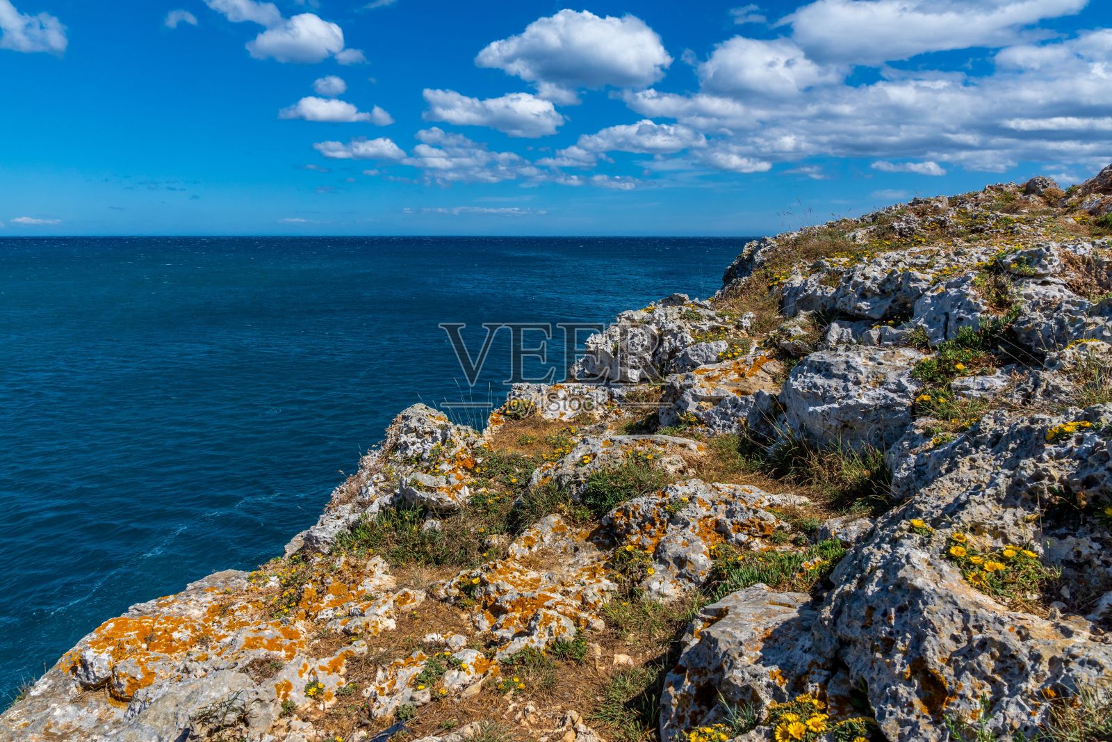 西班牙马略卡岛,阳光明媚的一天,被大海包围的岩石海岸景观照片摄影图片