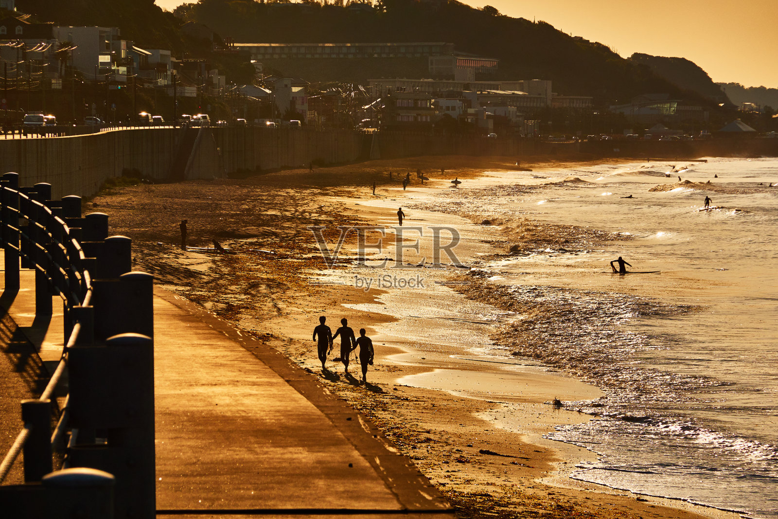 日出时站在沙滩上的人们的剪影照片摄影图片