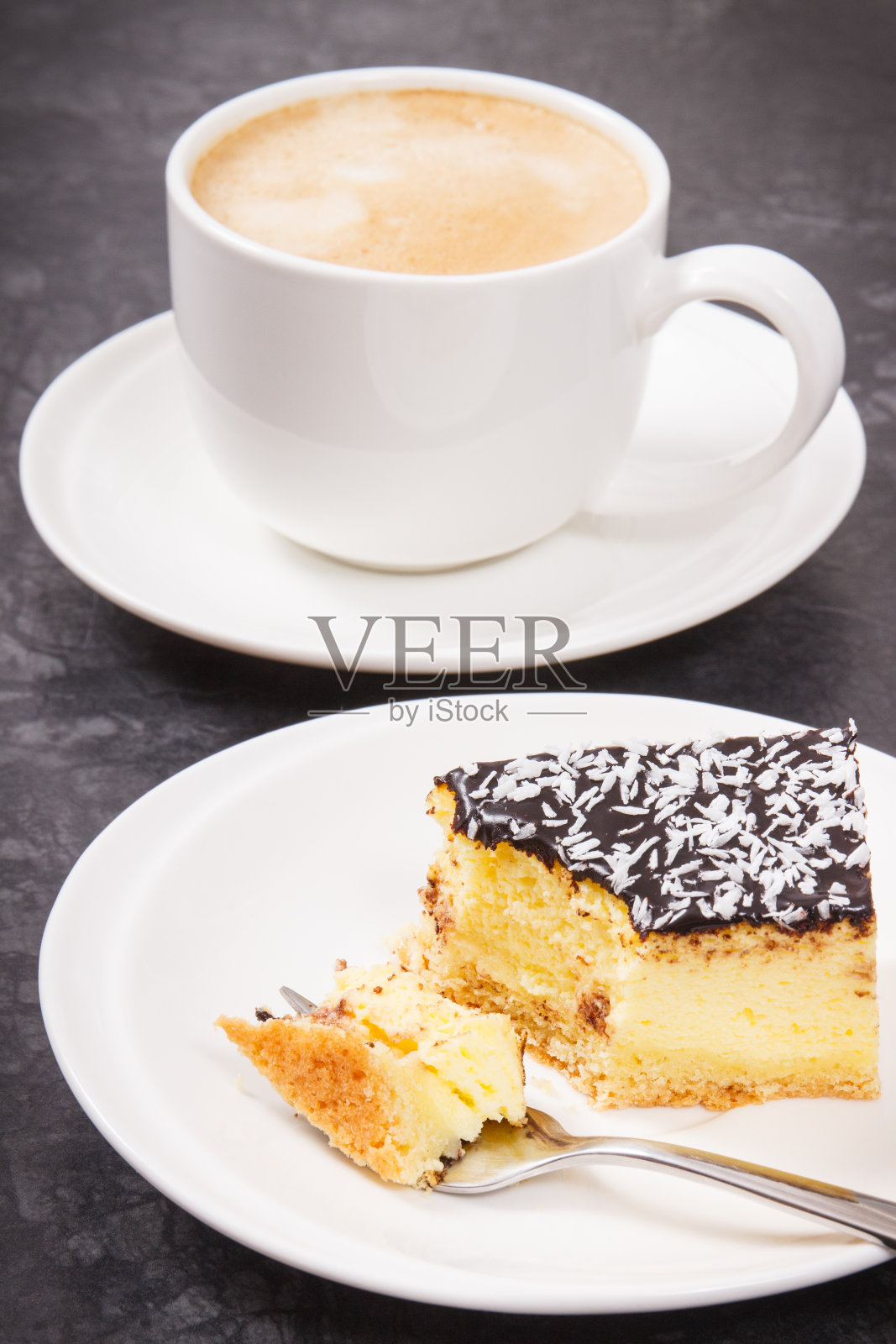 新鲜出炉的芝士蛋糕和一杯加牛奶的咖啡。美味的甜点照片摄影图片