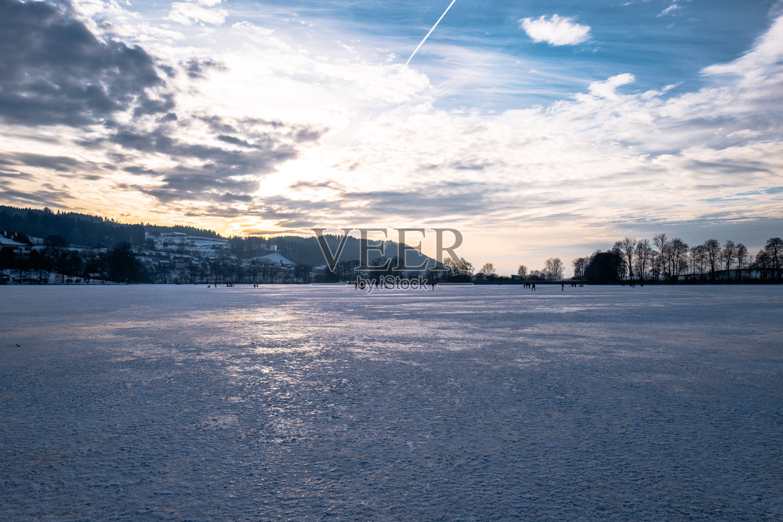 日落时,冰冻的湖对着天空的美景照片摄影图片