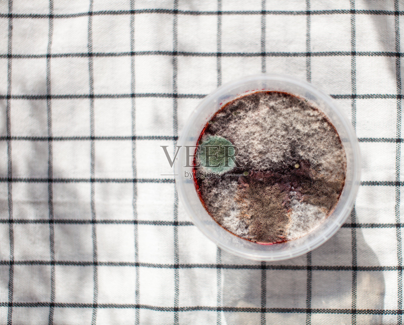 在一罐覆盆子果酱中发霉。有害健康。照片摄影图片