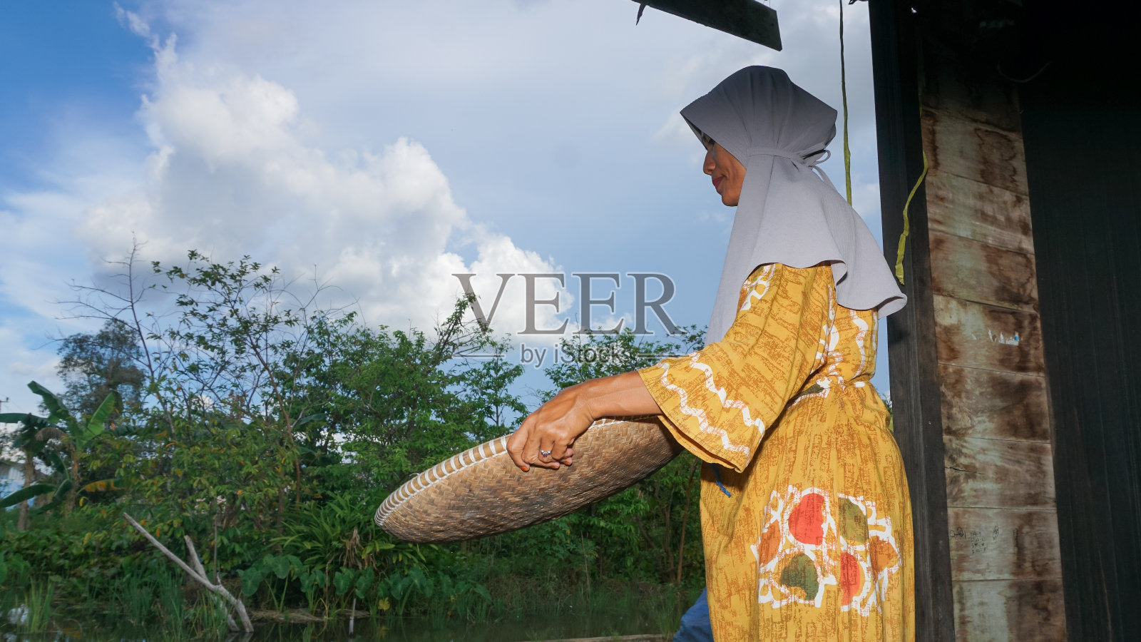 妇女正在家里簸米照片摄影图片