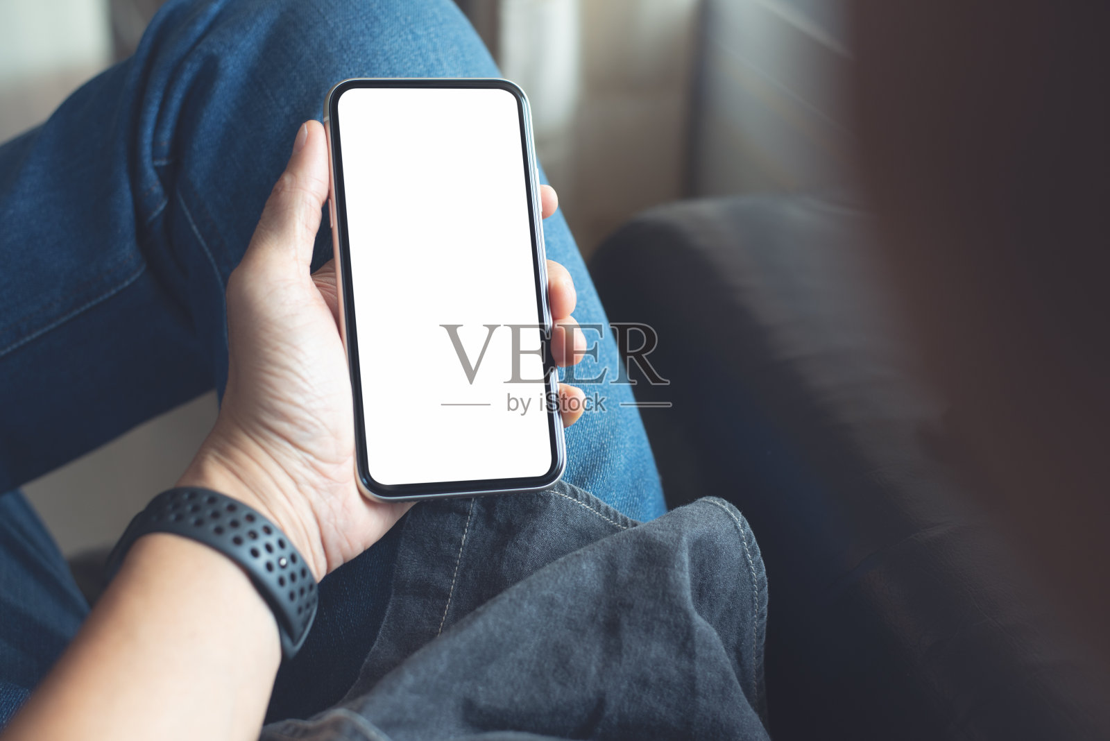 手机空白屏幕模板的模拟图像,男人坐在沙发上,手牵着手,看着手机屏幕照片摄影图片
