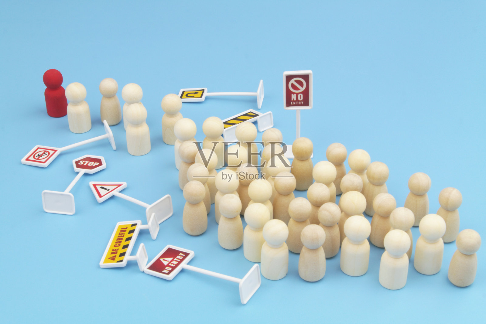 带着红头的木头人走过许多蓝色背景的禁酒令。照片摄影图片