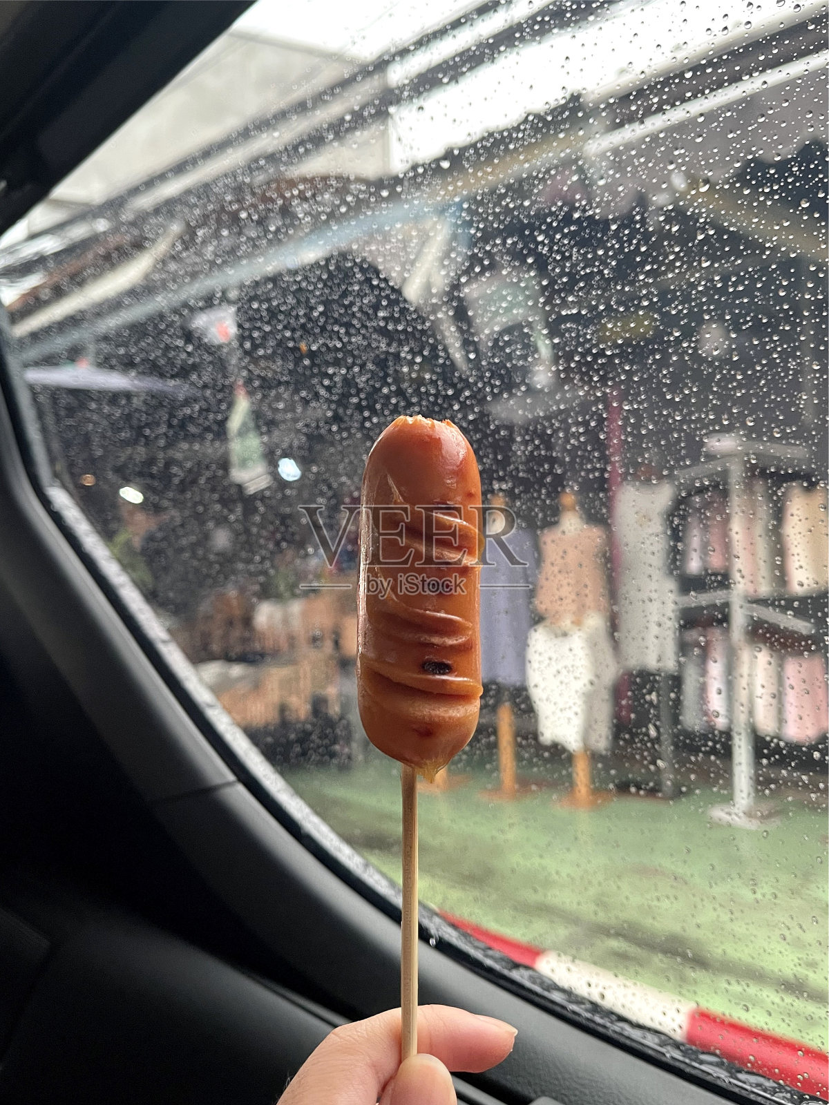 香肠插在一辆车里,背景是市场照片摄影图片