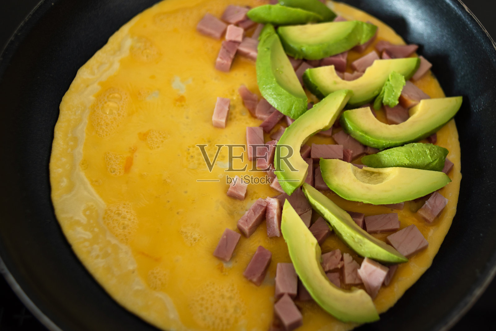 煎锅煎蛋,配火腿和新鲜蔬菜。照片摄影图片