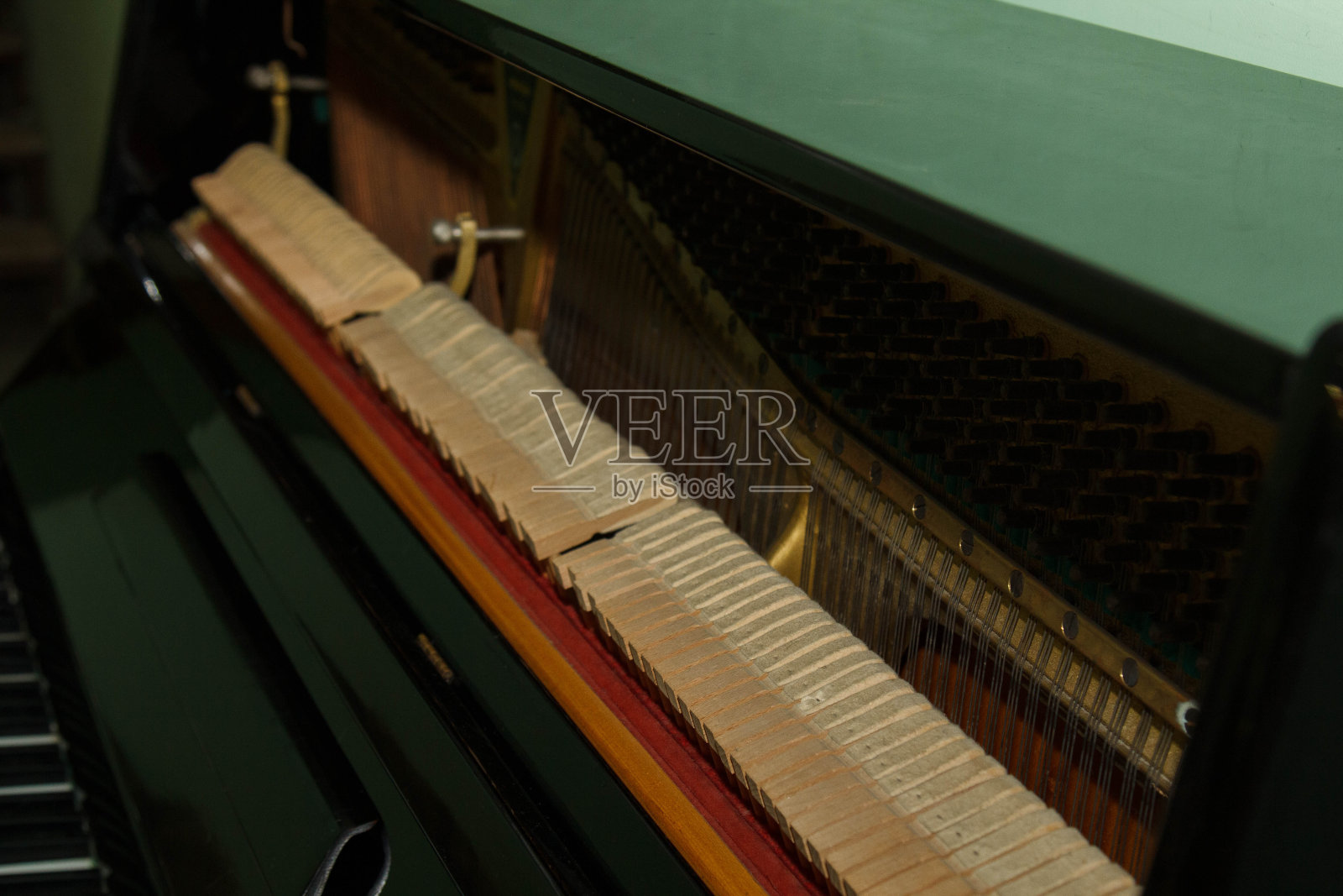 一架旧钢琴的内部部件特写-机械,琴弦。有选择性的重点。乐器的内部细节。照片摄影图片