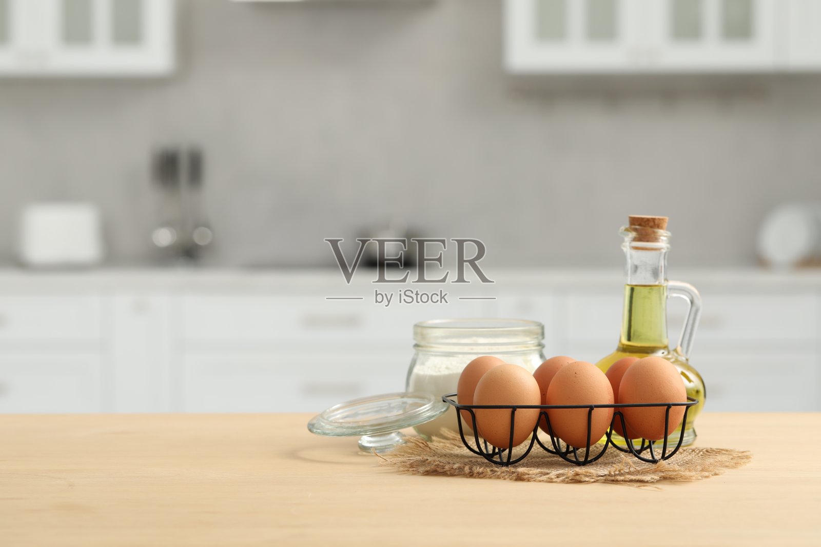 厨房的木桌上放着鸡蛋、面粉和油。文本空间照片摄影图片