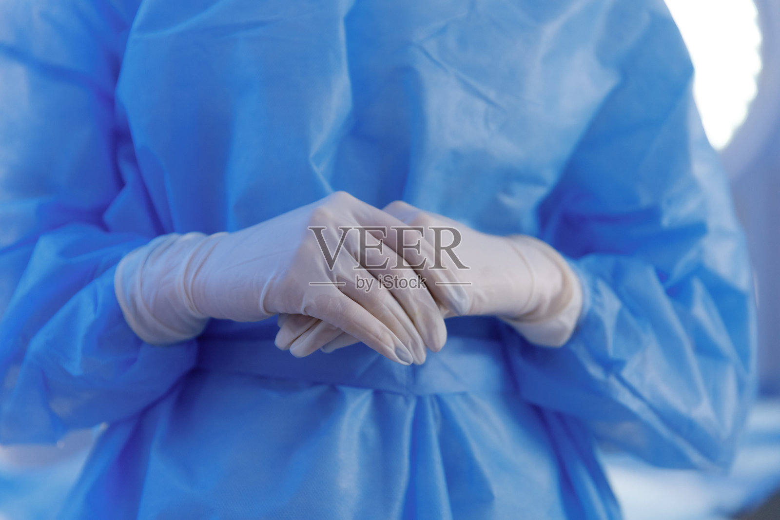 在镜头前捕捉外科医生在手术室准备工作的细节,他戴着防护装备和手套照片摄影图片