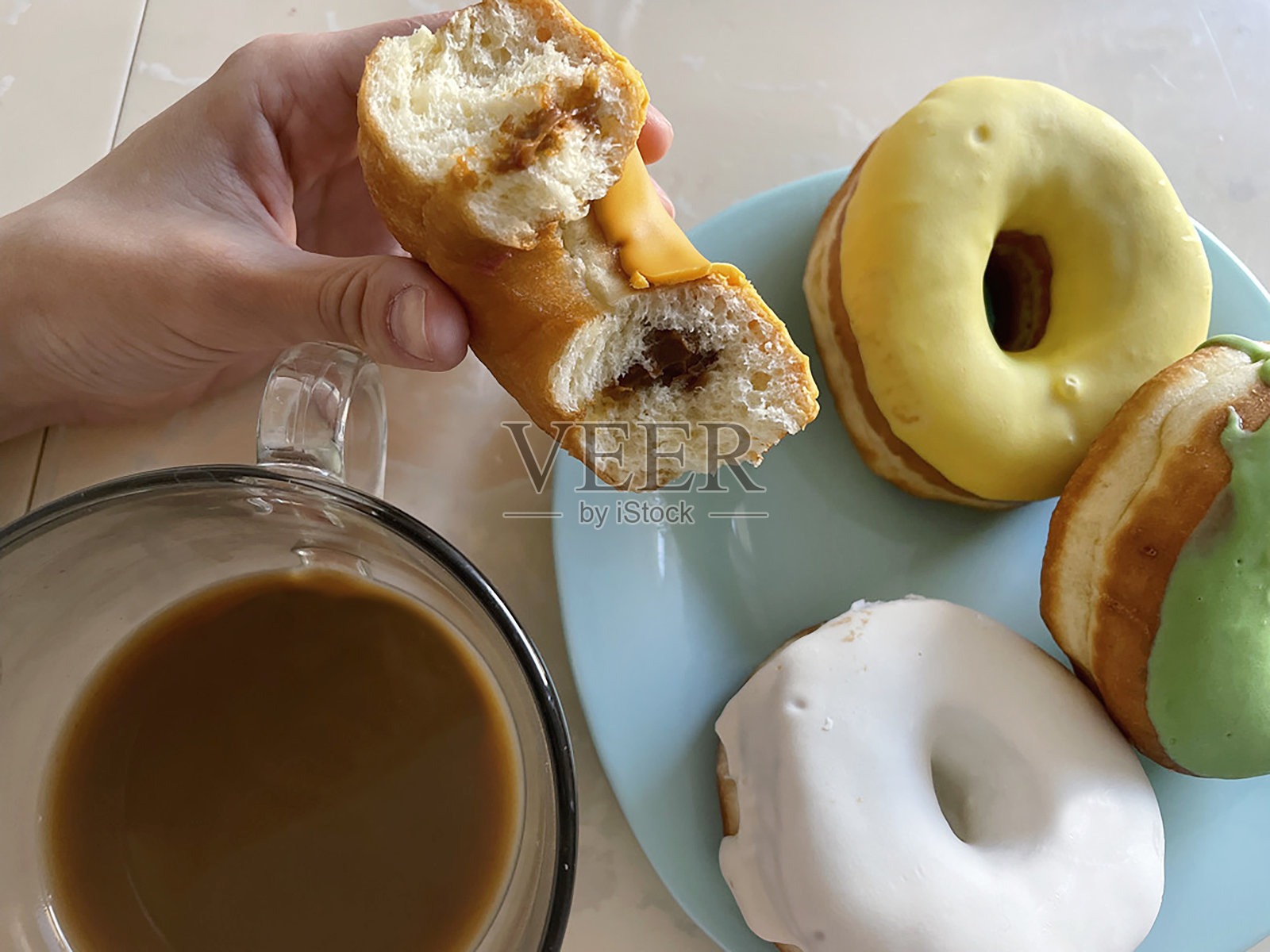 这个女孩喝着咖啡吃着美味的甜甜圈照片摄影图片