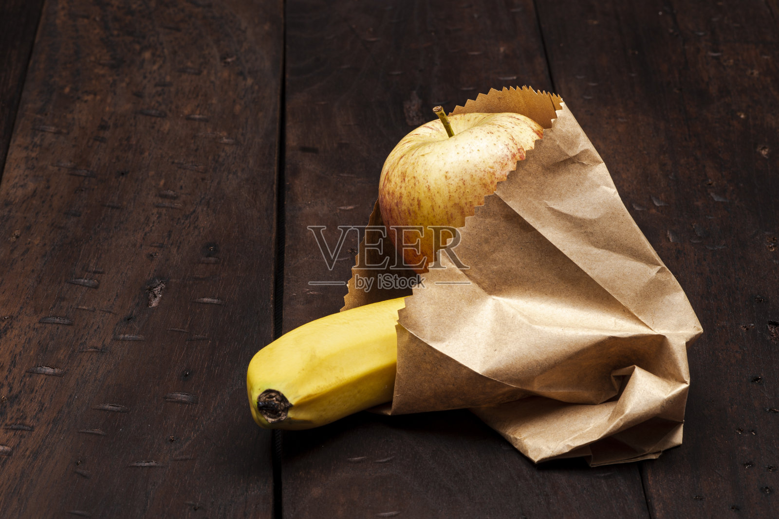 香蕉和红苹果水果装在纸袋里照片摄影图片